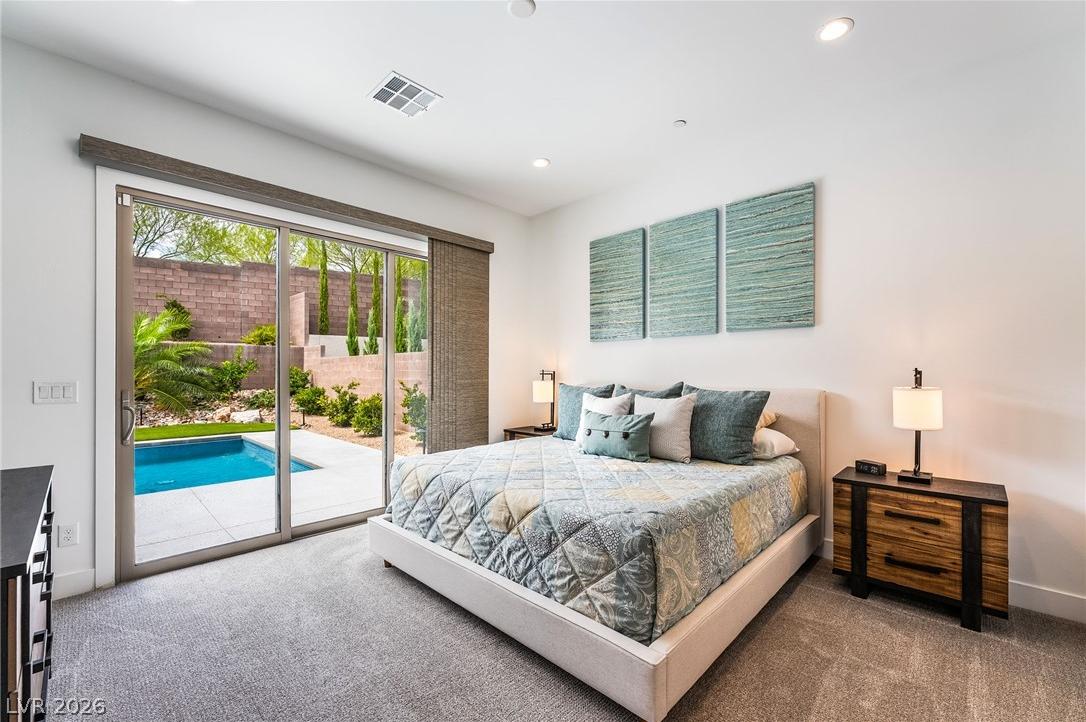 Luxurious primary bedroom suite with direct access to the private pool and spa