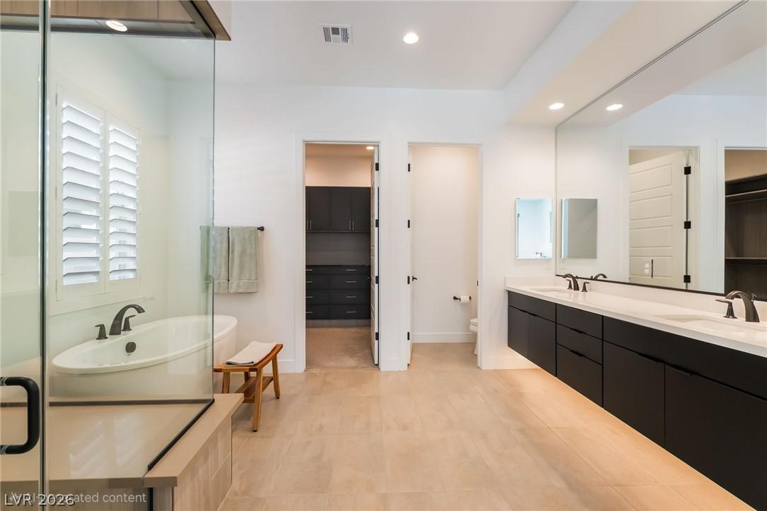 Contemporary zero-threshold walk-in glass shower in the primary bathroom