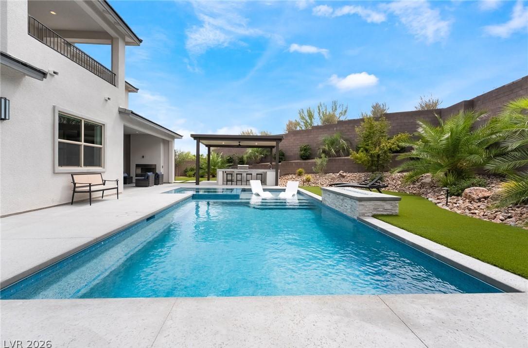 Low-maintenance luxury desert landscaping framing the pool at 127 Malpaso
